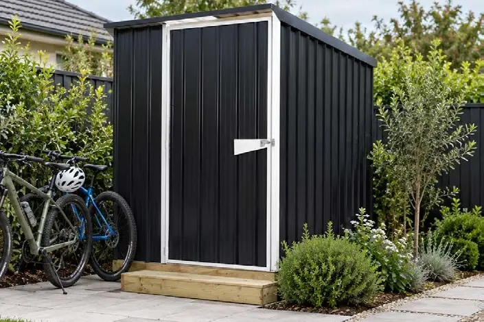 Compact dark bike shed beside a house